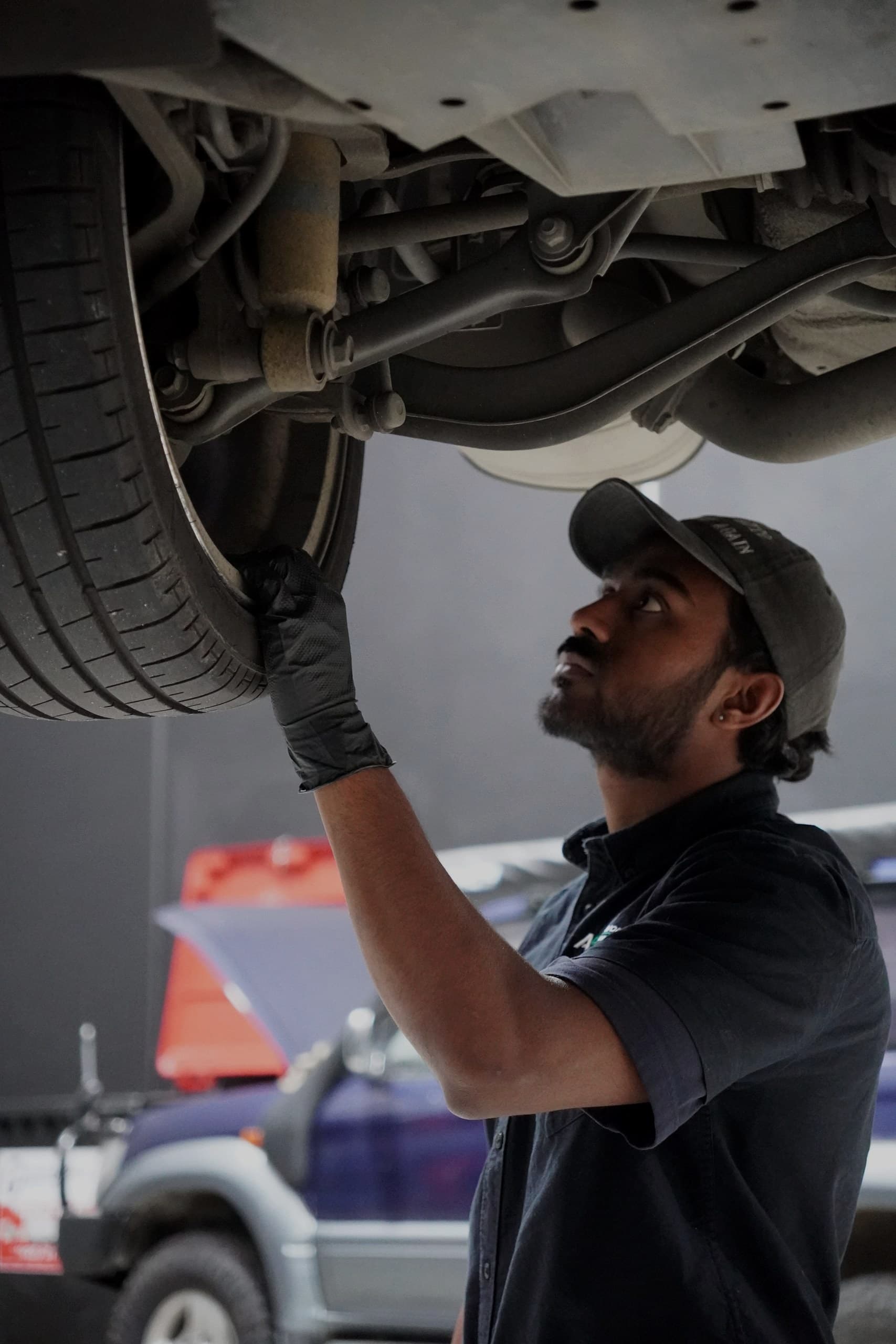 ASR technician inspecting the underside of a car on the hoist