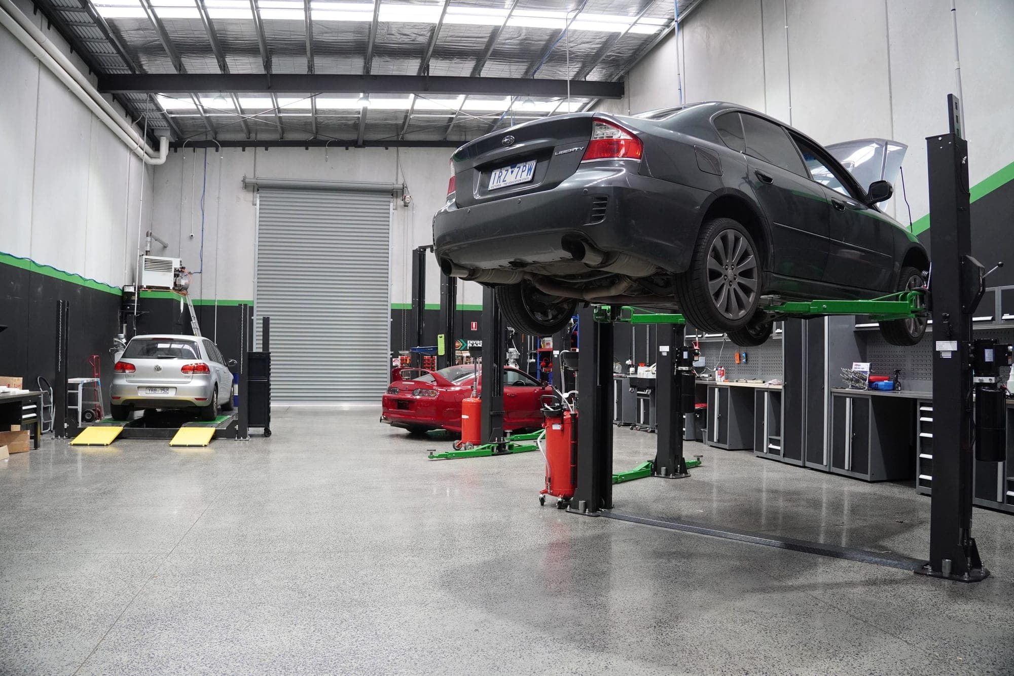 Vans and utes lined up in a workshop