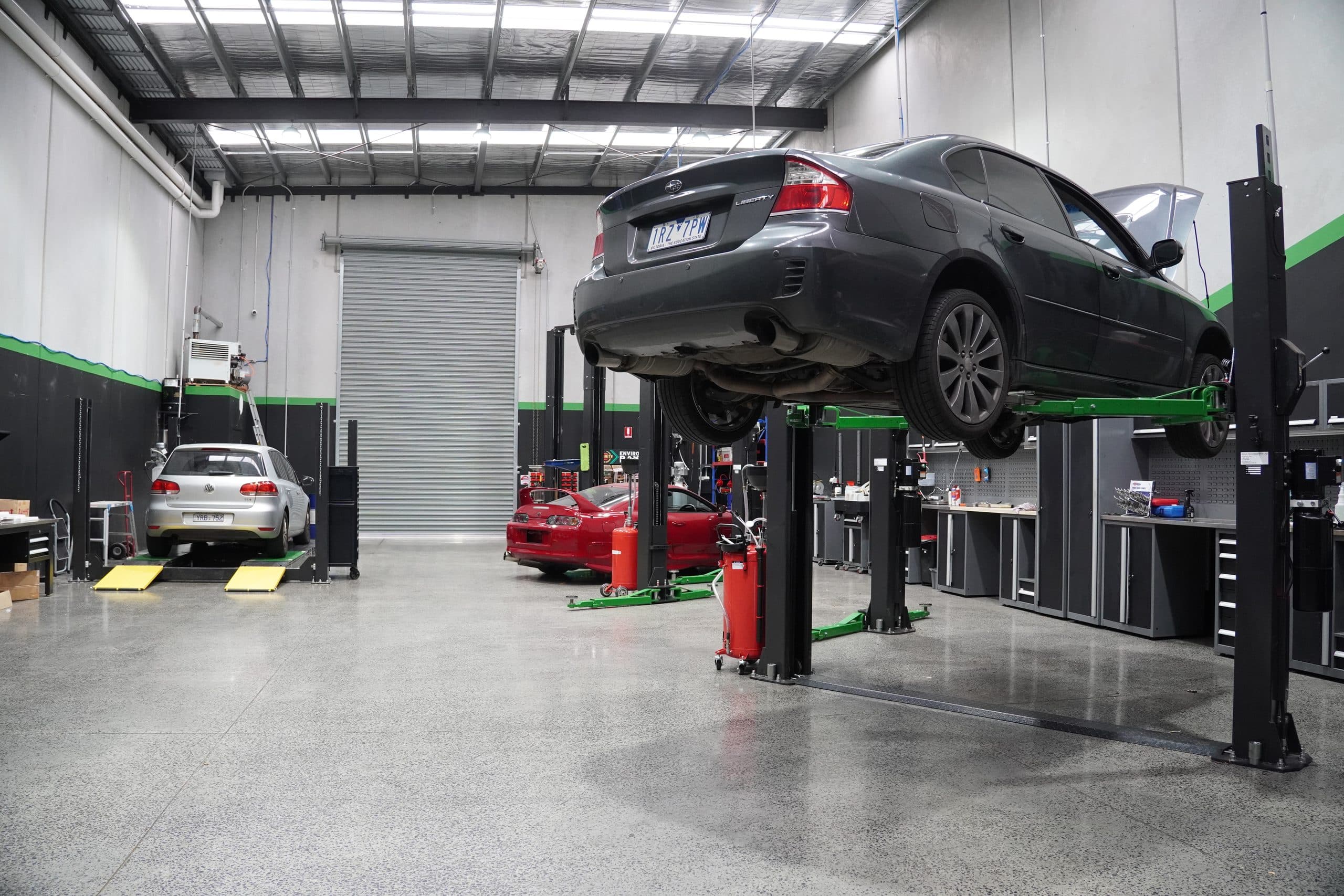Vans and utes lined up in a workshop